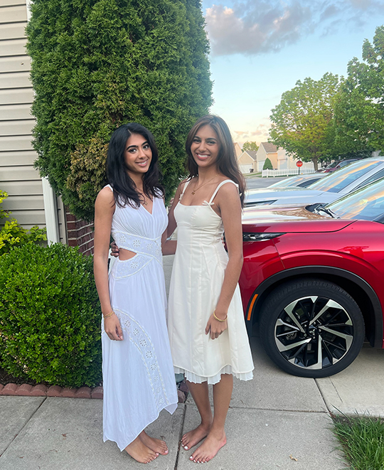 simran posing with a friend out on the sidewalk