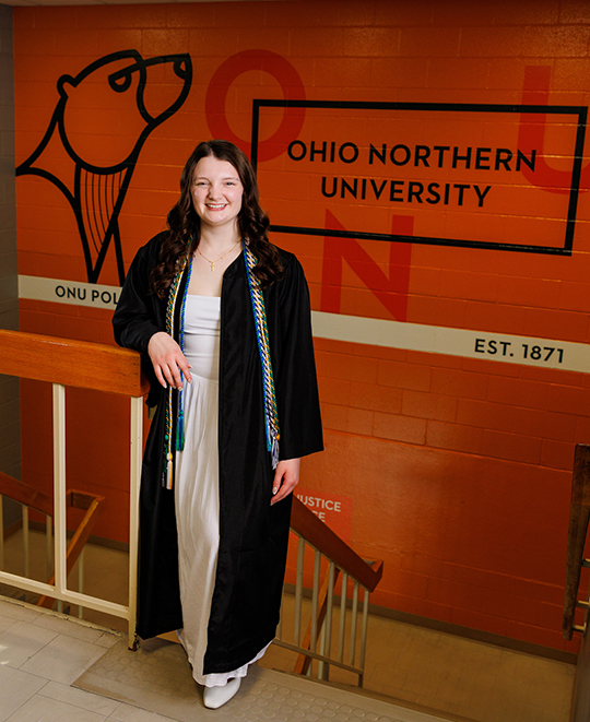 Julia standing in a staircase with the ONU polar bear on the wall