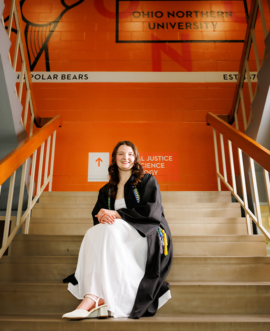 Julia seated on the stairs in a stair case
