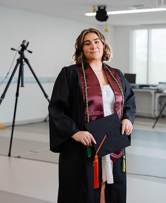 Madison posing in a white room with tripods behind her