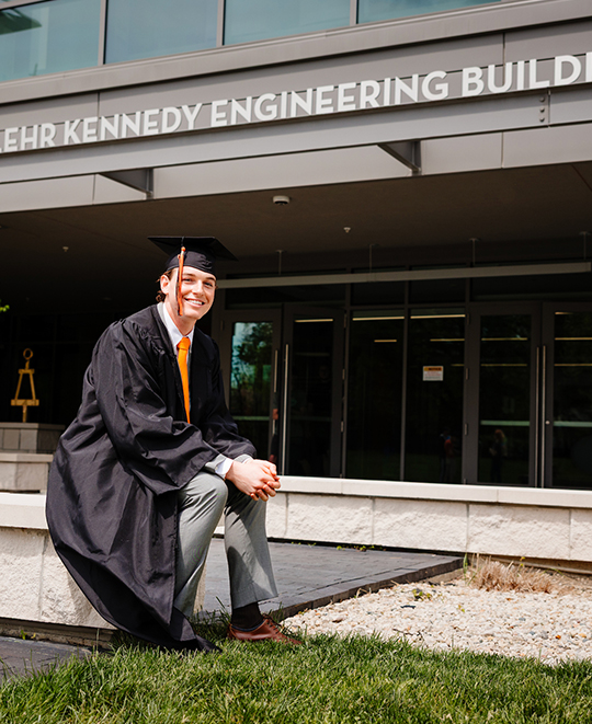 Mark seated on the ground outside the engineering building