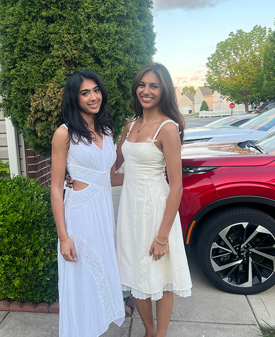 simran posing with a friend out on the sidewalk