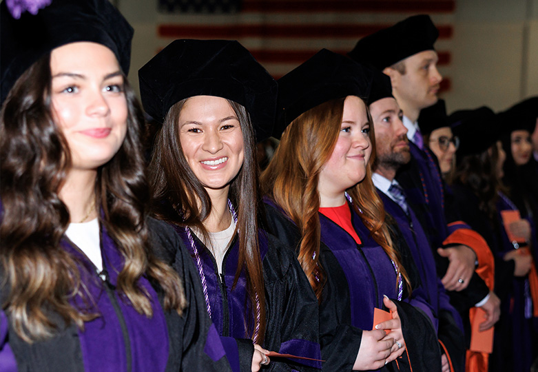 One female ONU law student in a line of graduates looking at photographer and smiling