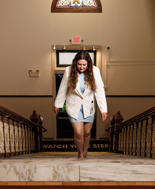 Evelynn Schneider walking up a grand courthouse staircase.