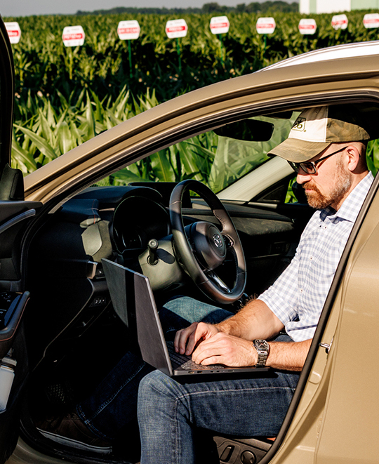 Dr. Eric Schultz sitting inside the car working on a laptop.