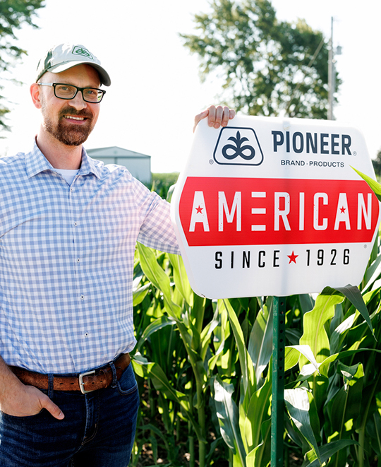 Dr. Eric Schultz standing in front of a Pioneer American agricultural research field.