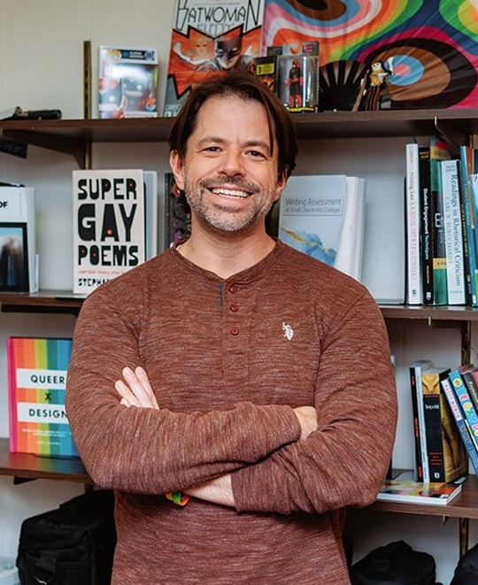 Bryan Lutz posing in front of a book case