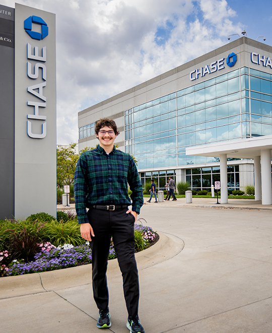 Chase McCluskey standing outdoors in front of a Chase glass building.