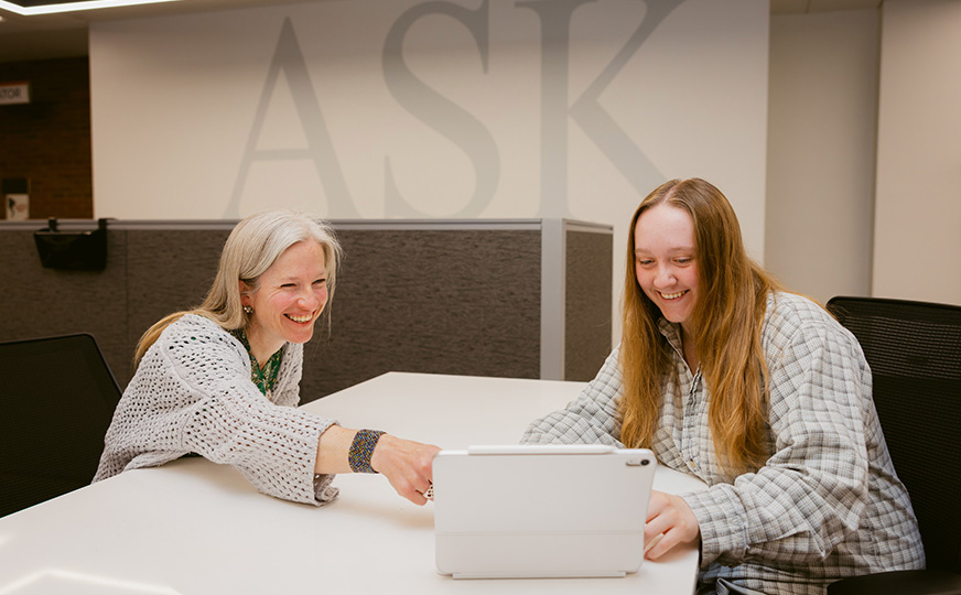 ONU staff helping student on a laptop