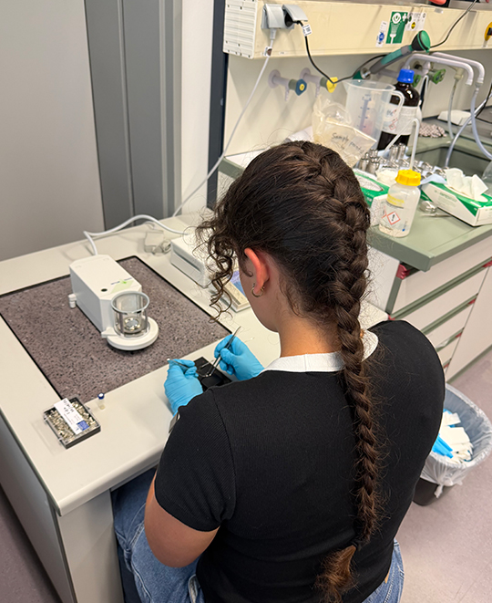Elizabeth Gruen working at a laboratory workbench with scientific equipment during her research at Karlsruhe Institute of Technology.