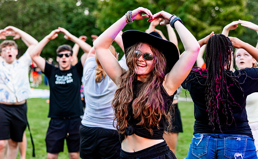 A group of enthusiastic students dancing outdoors