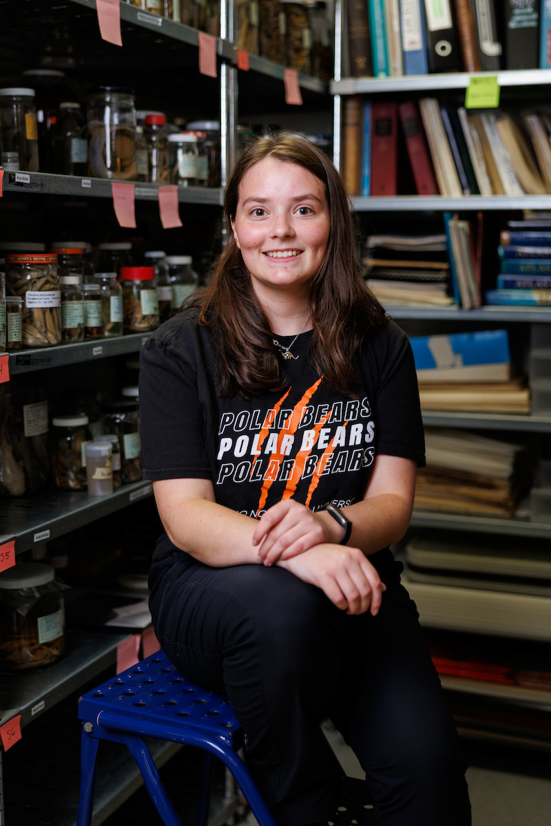 Jacey Wonderly sitting in lab with historical information