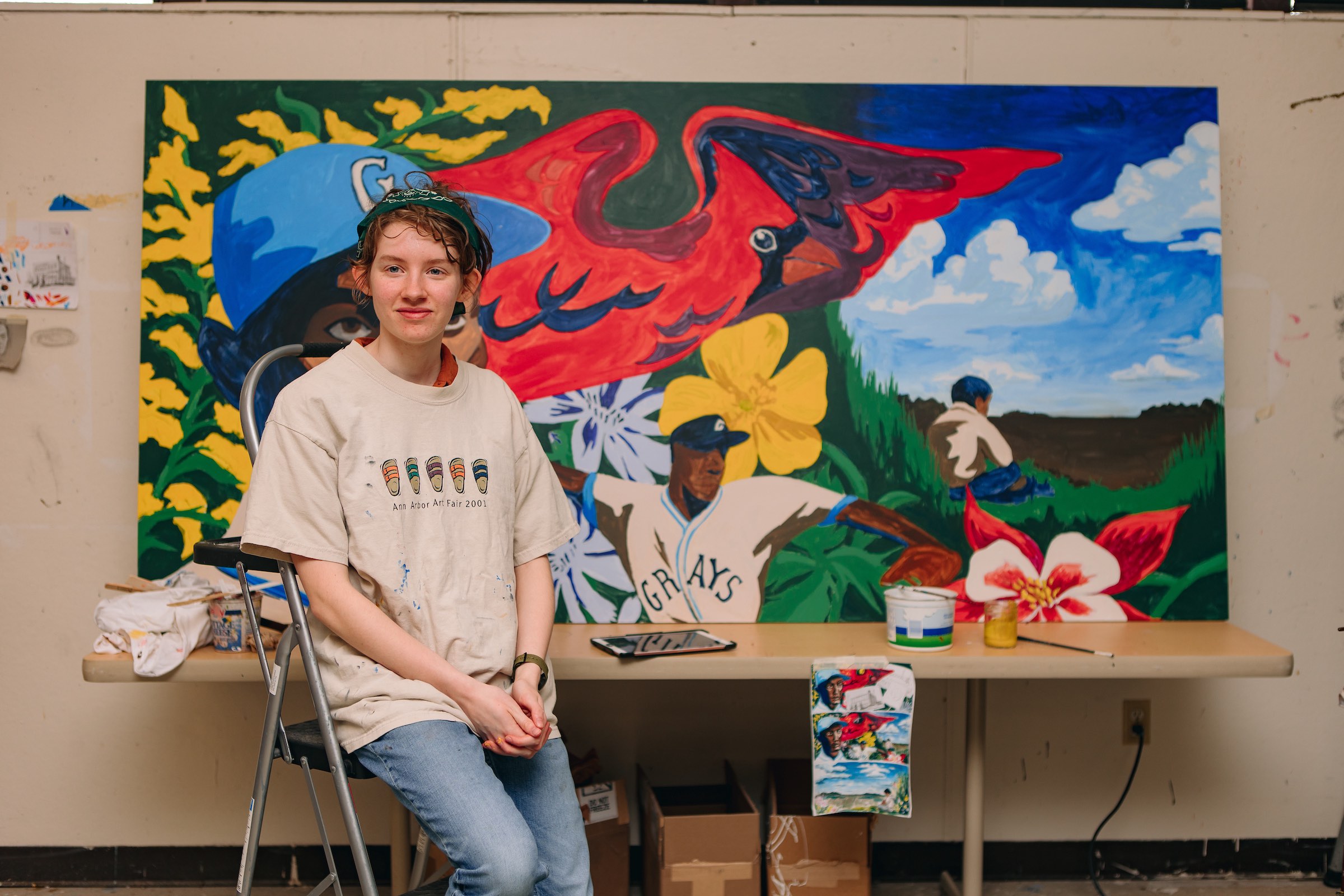 Aubrey Davis sits in front of a mural of Ray Brown.