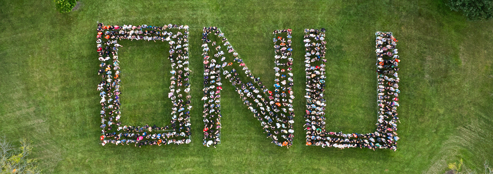Freshman Students &amp; Staff standing on lawn spelling O N U