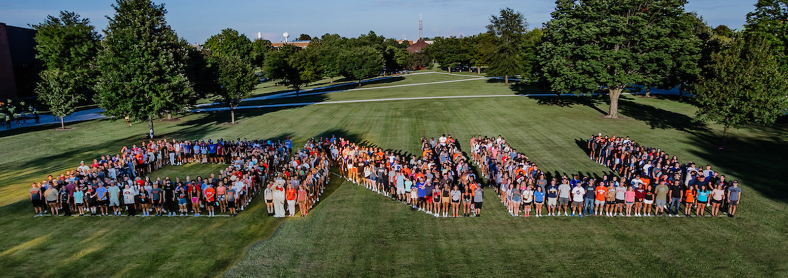 Students & Staff standing on lawn spelling O N U 