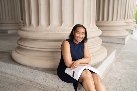 Dania Lofton in a navy dress seated on white steps