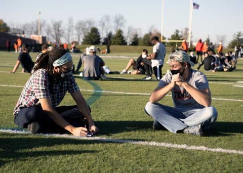 Two people talking at football stadium