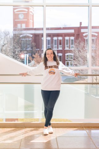 Photo of Ammryn standing against glass wall