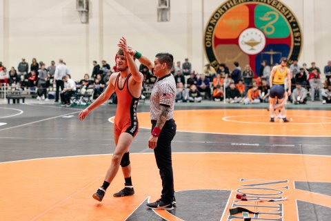 Jacob Reed with an official during a wrestling match