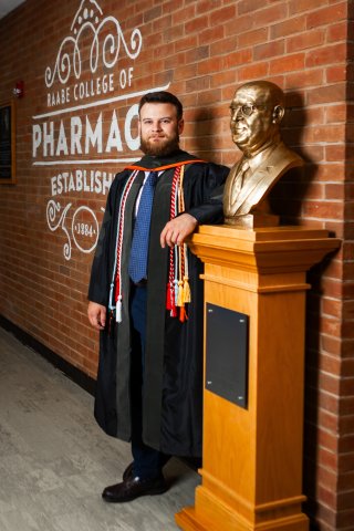Photo of Reese standing next to a statue