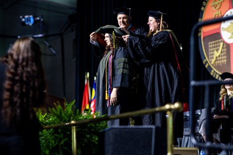 ONU Pharmacy commencement photo of a student getting their hood placed