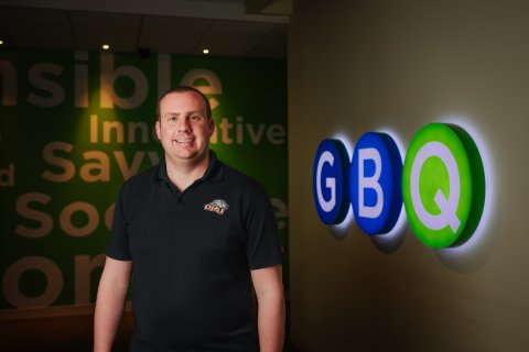 Photo of Rob standing next to GBQ sign