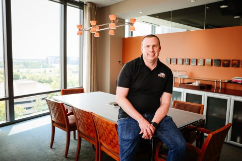 Photo of Rob Roll posing by leaning on a table