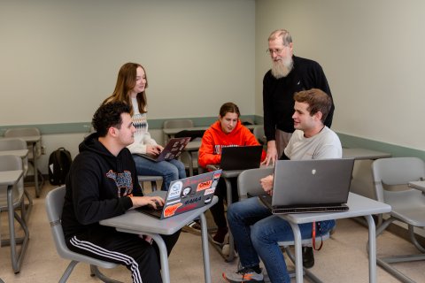 Photo of person with multiple students in a group.
