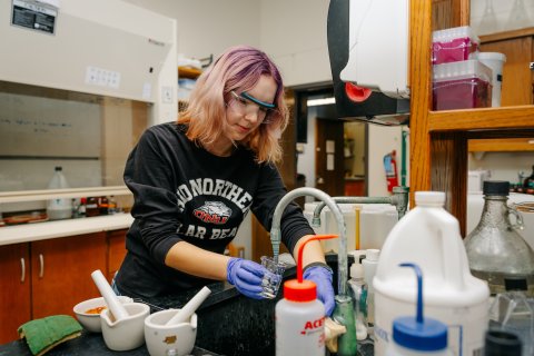 Photo of Emily in a lab working