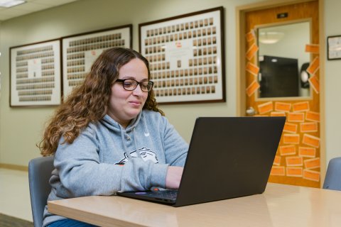 Photo of Chelsie sitting working on her laptop