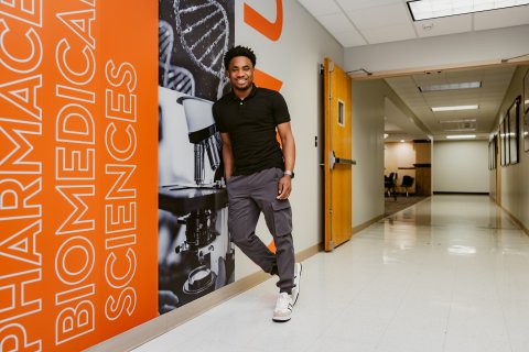 Photo of Adebowale leaning against a wall posing 