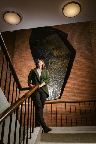 Dr. Carla standing in the stairwell looking off to the side