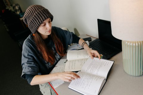 Braxtyn working on a desk with 2 notebooks open in front of her