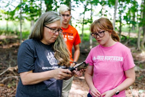 ONU instructor, Kat Krynak, holding a box turtle with students around her