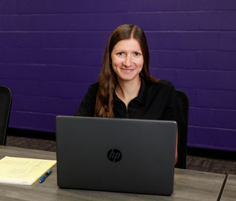 Tessa seated behind a laptop working