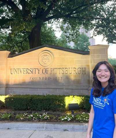 Photo of Aleece near a University of Pittsburg Signage