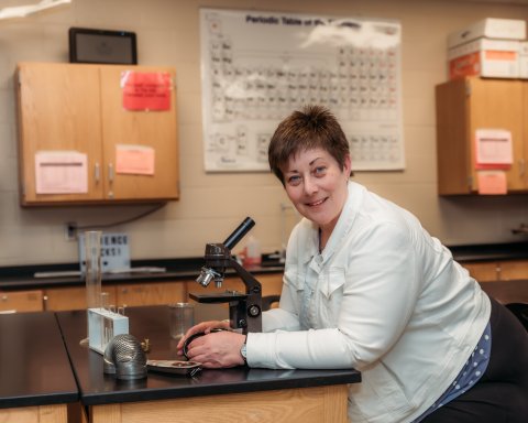 Photo of Ann about to look into a microscope