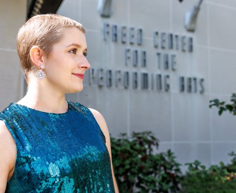 Cassandra Kurek smiling warmly with the Freed Center for the Performing Arts on the building in the distance