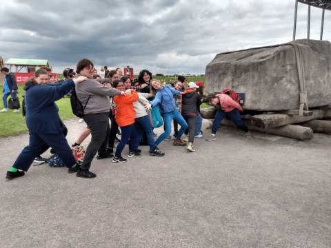 Photo of ONU students appearing to pull a giant boulder