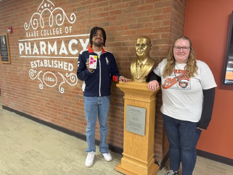 Another photo of the 2 ONU Pharmacy students posing next to a statue