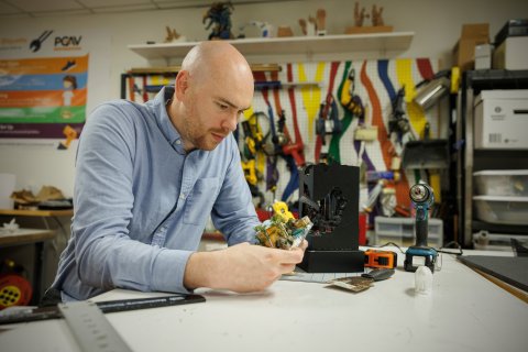 Photo of Jonathan holding landscape sculpture.