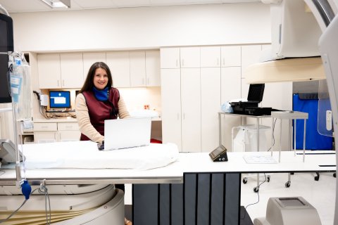 Photo of Angela with a radiation vest on working on a computer