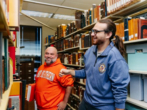 Photo of Pablo in a book isle with another person