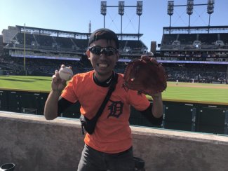 International student holding a baseball