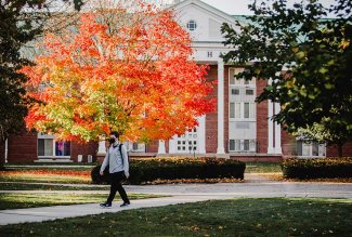 Student walking on Ohio Northern University's campus during a fall day.