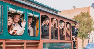 Photo of folks on a trolley during homecoming parade