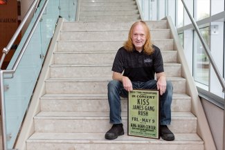 Photo of Jimmy Wilson holding a KISS poster