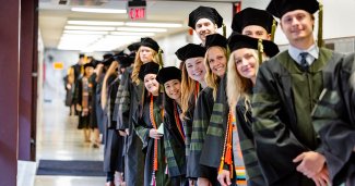 Photo of ONU grads in a line wearing their caps and gowns
