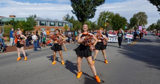 Photo of homecoming parade and the cheerleaders mid cheer