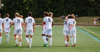 Photo of ONU mens soccer players walking away from camera, with a couple of them congratulating each other